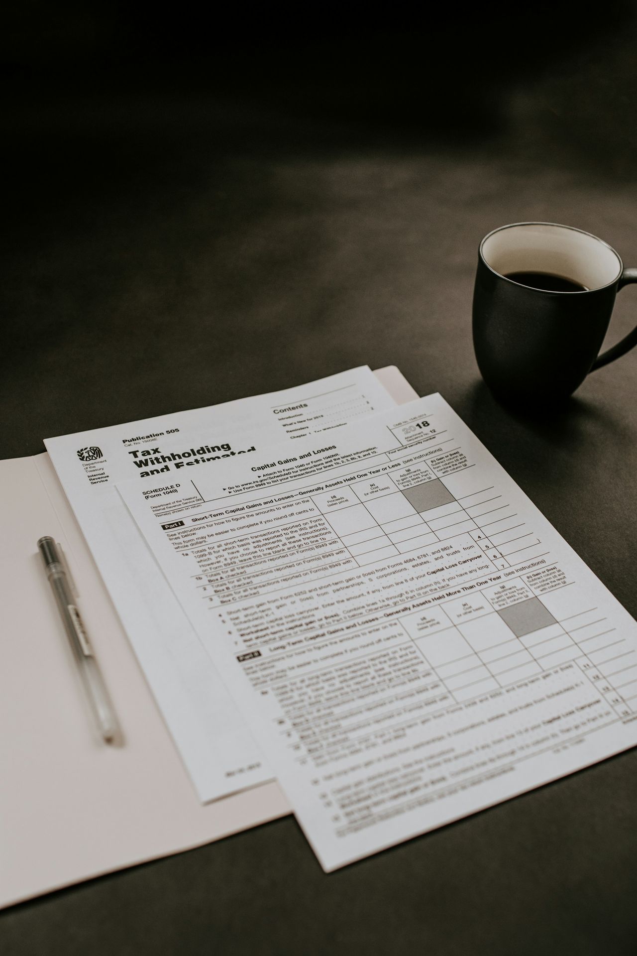 black ceramic mug beside white printer paper black ceramic mug beside white printer paper