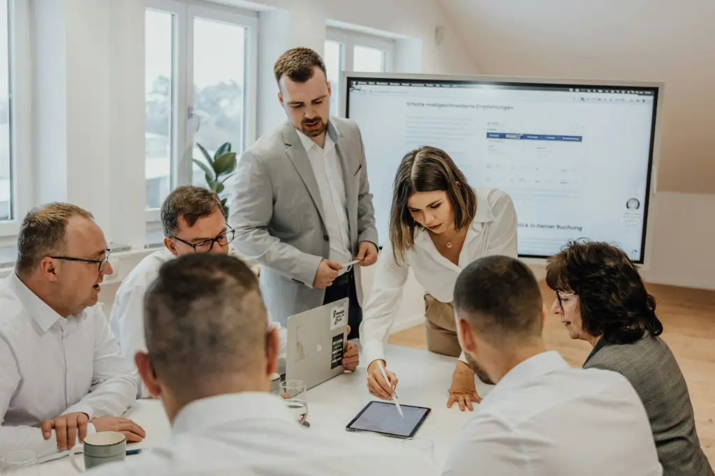 Common Use Cases for Odoo and Google Workspace Integration a group of people sitting around a table with laptops